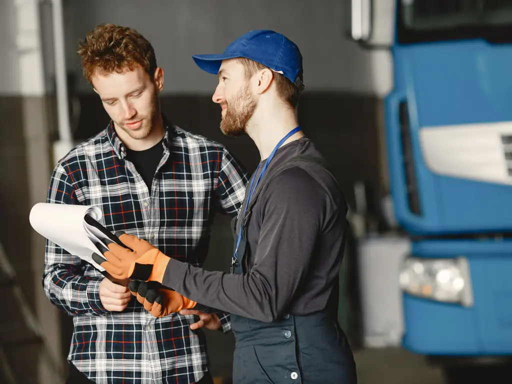 A mechanic going through the job sheet with a customer